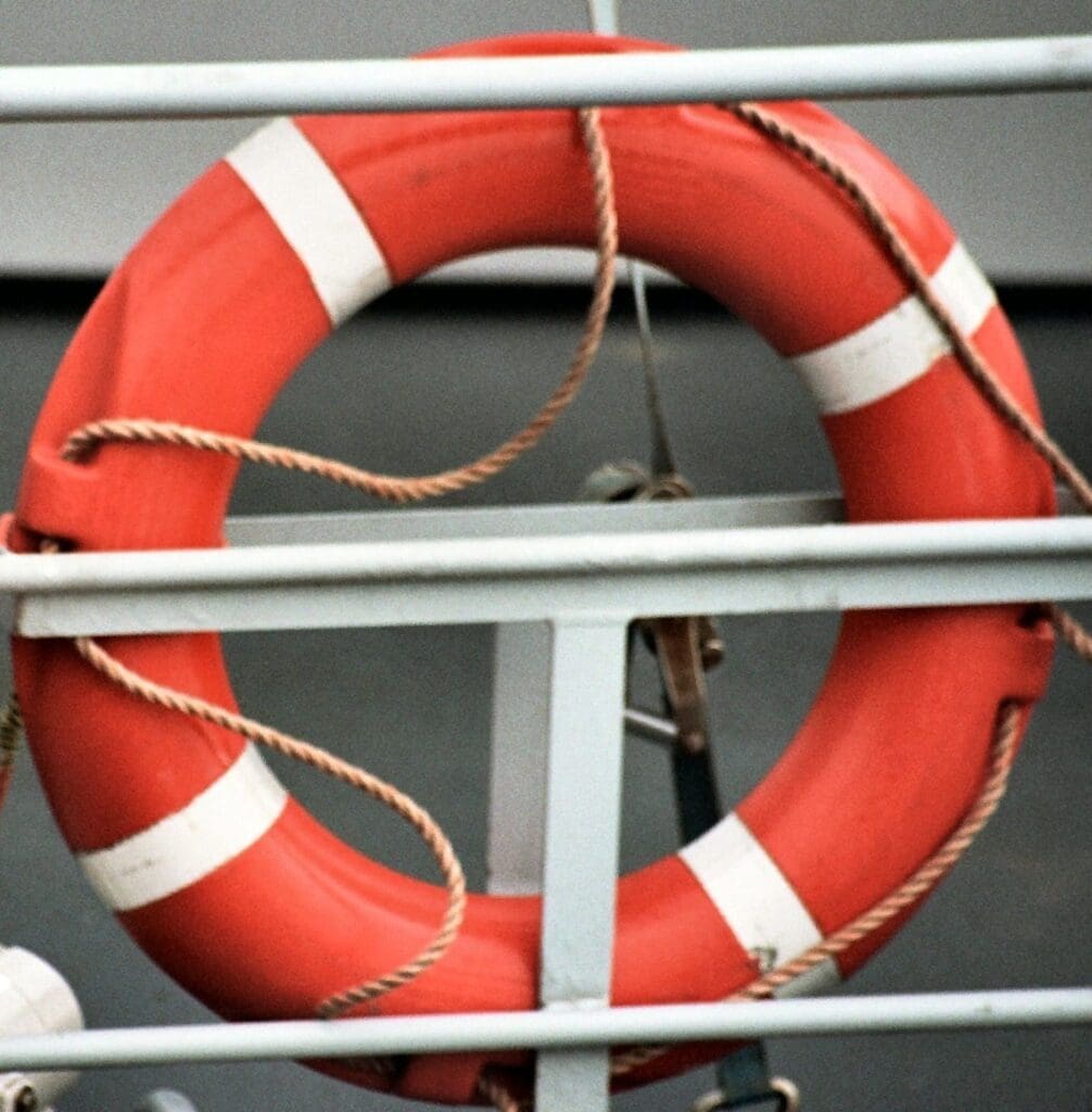 A life preserver on the railing of a ship.