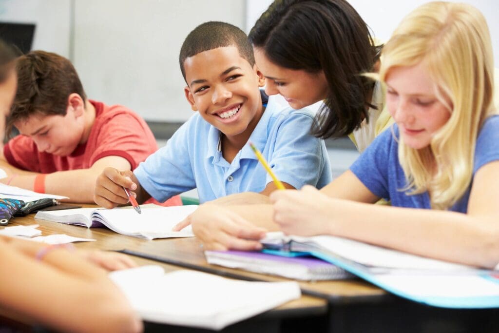 A kid smiling and sitting in the classroom